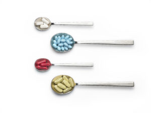 Spoons with tablets and capsule hero branding image